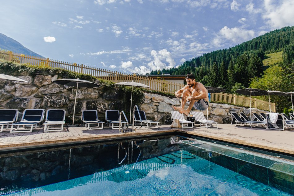 Das Outdoor-Pool im Sporthotel Wagrain lädt zu einem Sprung ins Wasser ein